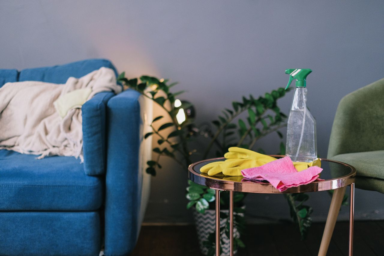 services-01 Latex gloves and spray detergent set on a table in a stylish living room during the day
